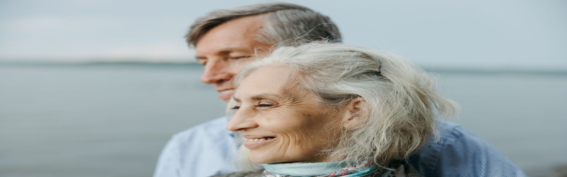 Senior couple smiling together by the water, representing healthy aging with internal medicine care in Shenandoah, TX